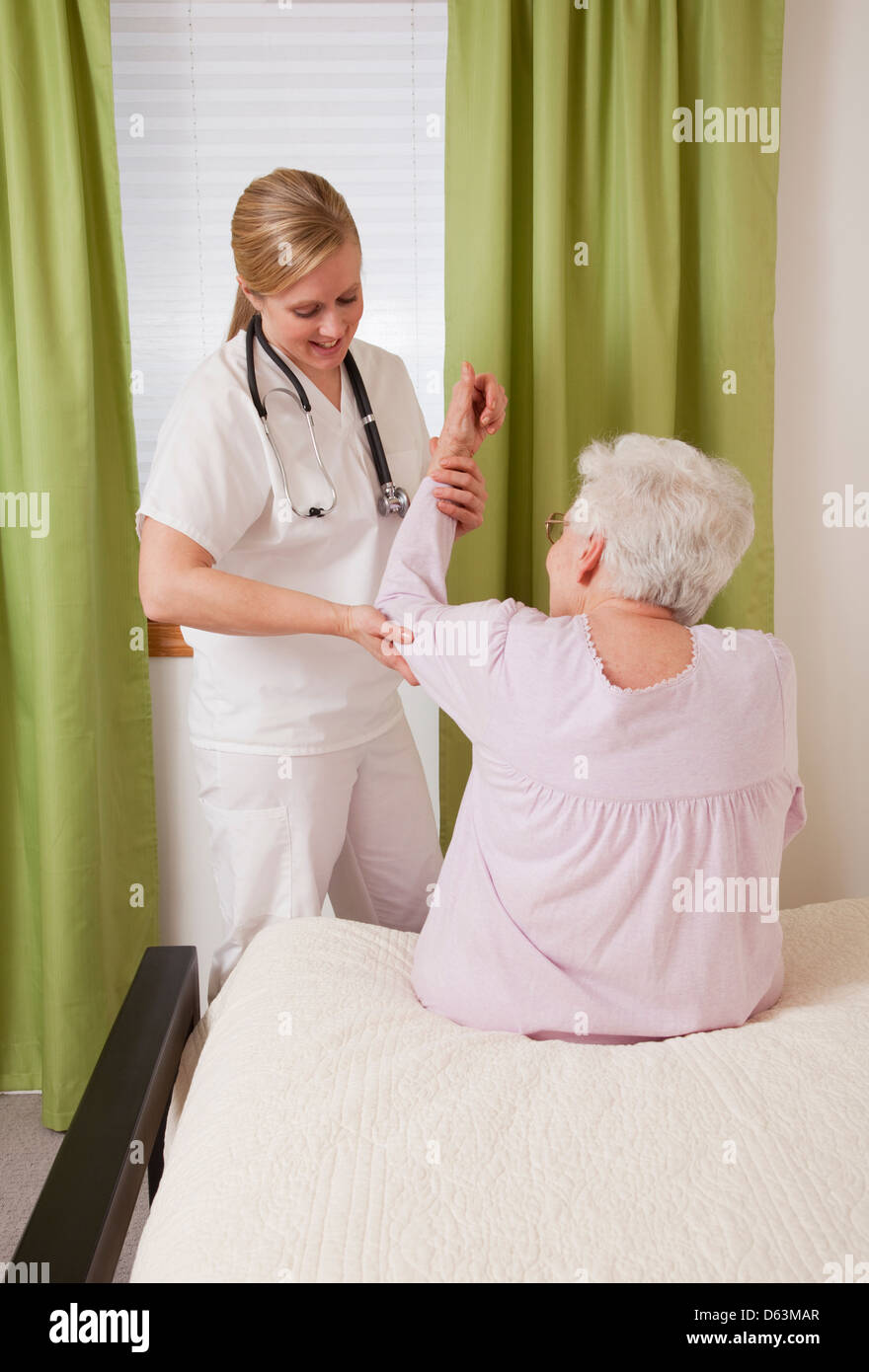 Nurse exercising with senior woman Stock Photo