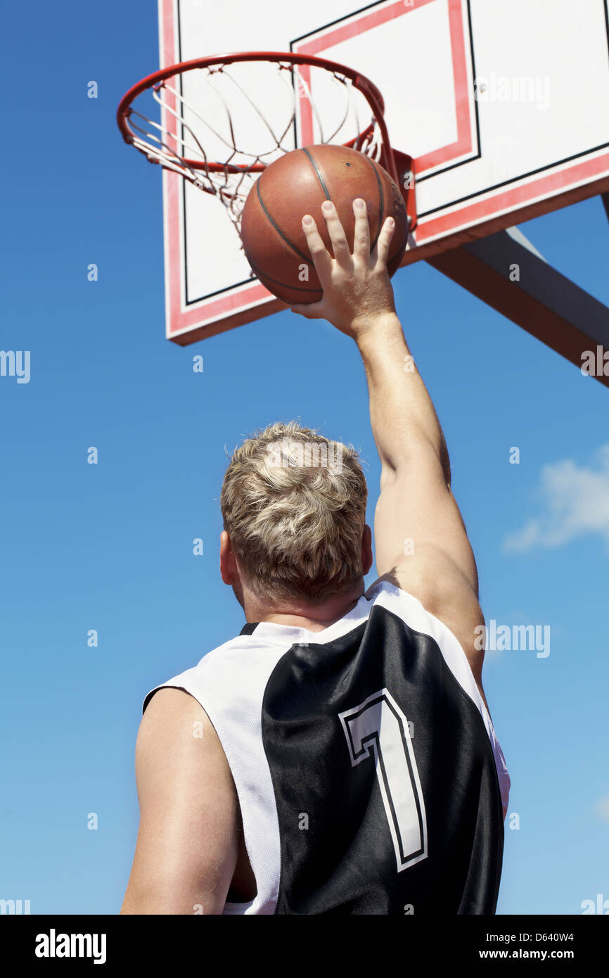 Basketball player throws ball in the basket Stock Photo Alamy