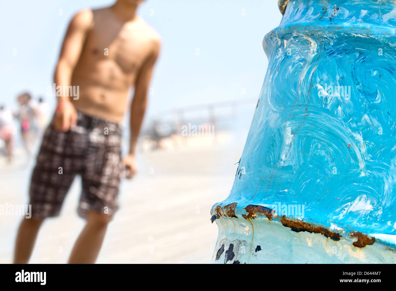 Young man walking on beach promenade Stock Photo