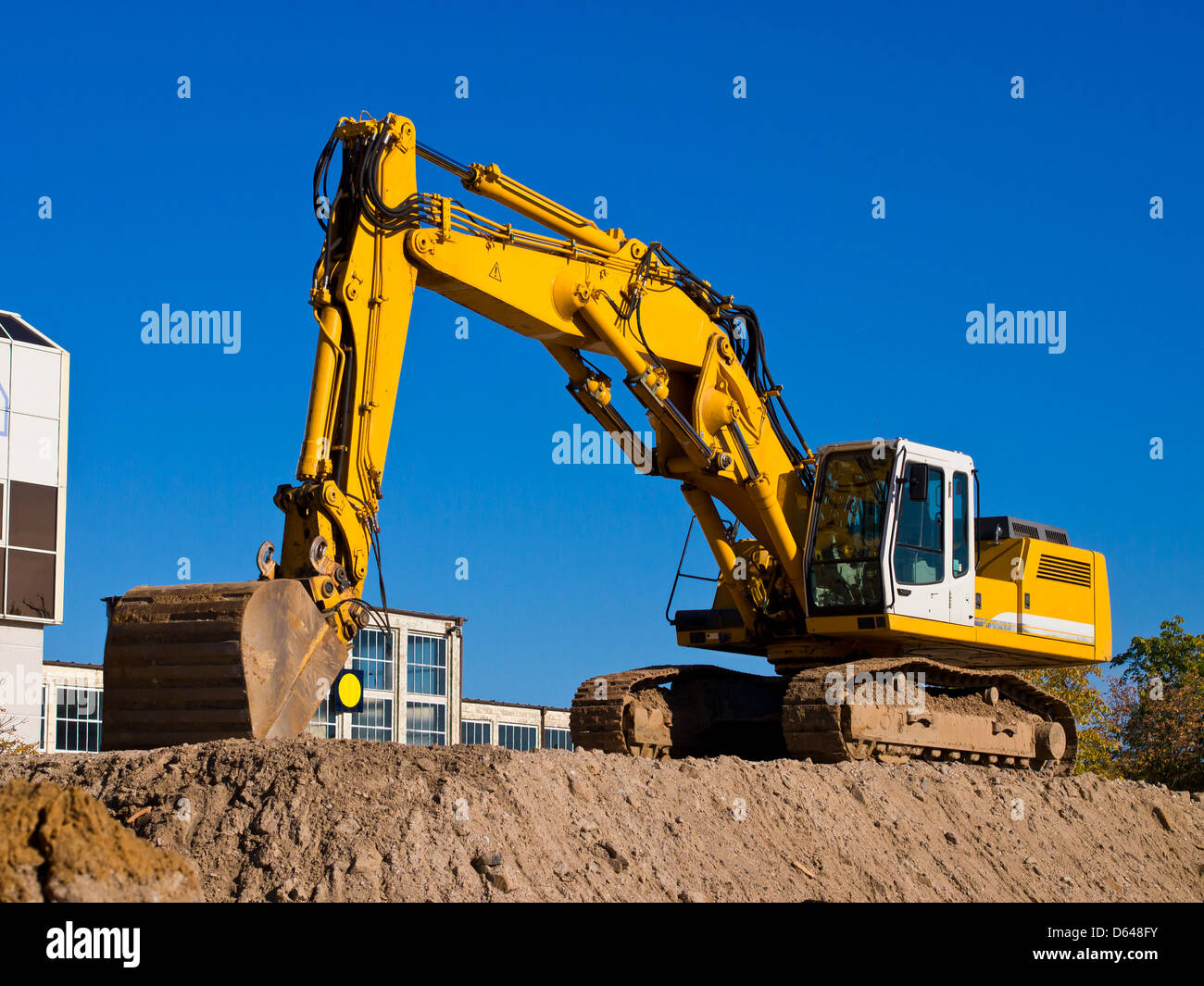 yellow excavator digging earth on construction site Stock Photo