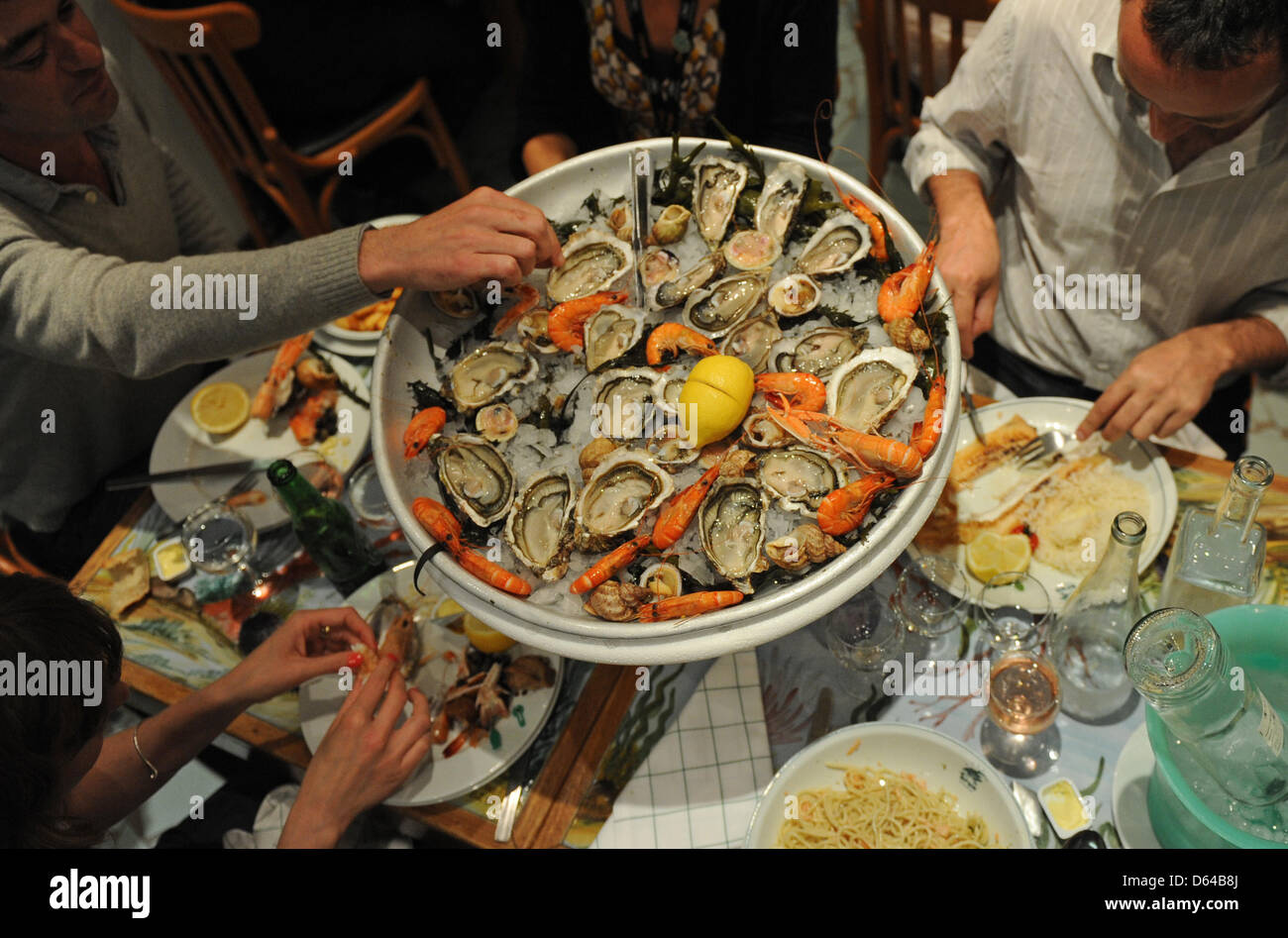 A group of people eat seafood at a restaurant in Cannes, France, 22 May