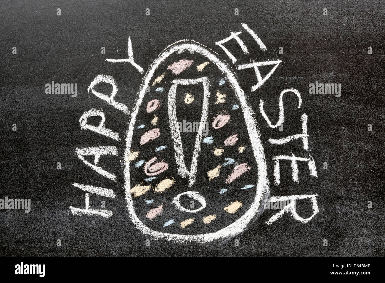 happy easter phrase handwritten on the school blackboard around painted egg picture with exclamation point Stock Photo