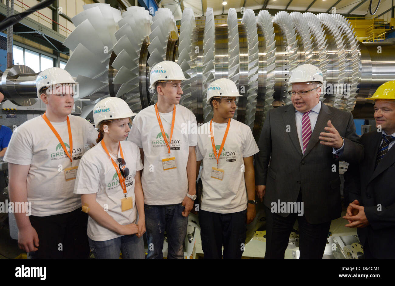 German Environment Minister Peter Altmaier speaks to pupils at a Siemens plant that manufactures gas turbines in Berlin, Germany, 25 May 2012. Plant manager Andreas Fischer-Ludwig is on the right. Mr Altmaier is en route to pronmote 'Green Day', a day dedicated to green jobs, that is scheduled to take place annually on 12 November. Photo: Rainer Jensen Stock Photo