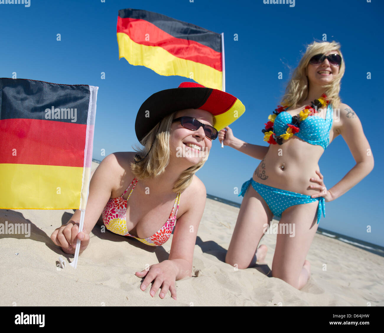ILLUSTRATION - Natalie and Jule (R-L) hold German flags in preparation for the European Championships at the Baltic Sea beach of Trassenheide, Germany, 25 May 2012. Public broadcaster ZDF plans to cover the Euro 2012 and additional programmes from the Island of Usedom. Photo: Stefan Sauer Stock Photo