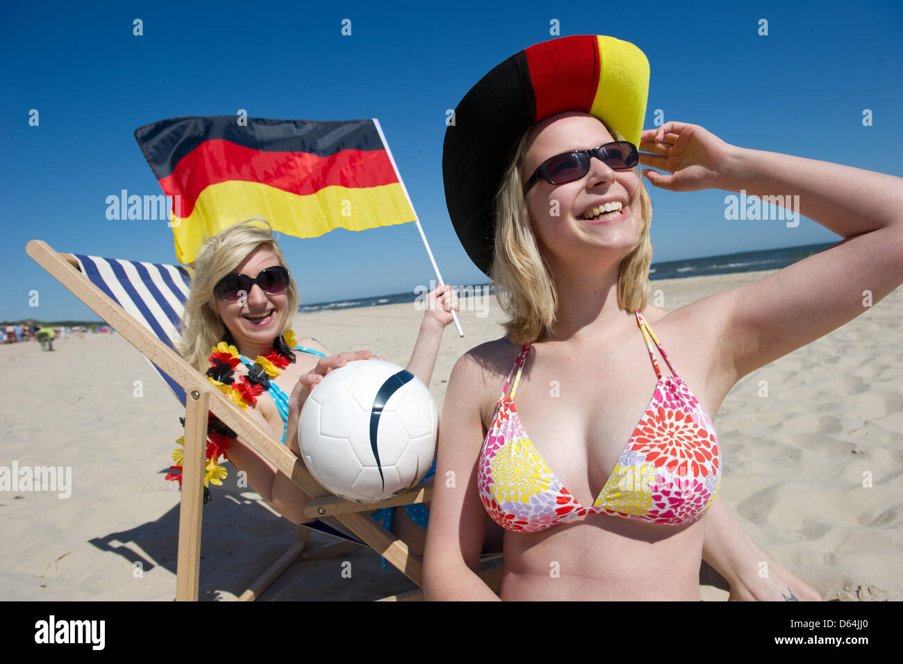 ILLUSTRATION - Natalie and Jule (L-R) hold German flags in preparation for the European Championships at the Baltic Sea beach of Trassenheide, Germany, 25 May 2012. Public broadcaster ZDF plans to cover the Euro 2012 and additional programmes from the Island of Usedom. Photo: Stefan Sauer Stock Photo