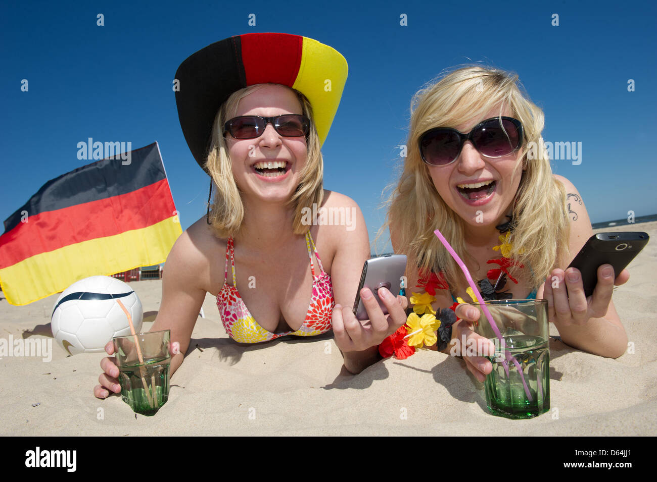 ILLUSTRATION - Natalie and Jule (R-L) hold German flags in preparation for the European Championships at the Baltic Sea beach of Trassenheide, Germany, 25 May 2012. Public broadcaster ZDF plans to cover the Euro 2012 and additional programmes from the Island of Usedom. Photo: Stefan Sauer Stock Photo
