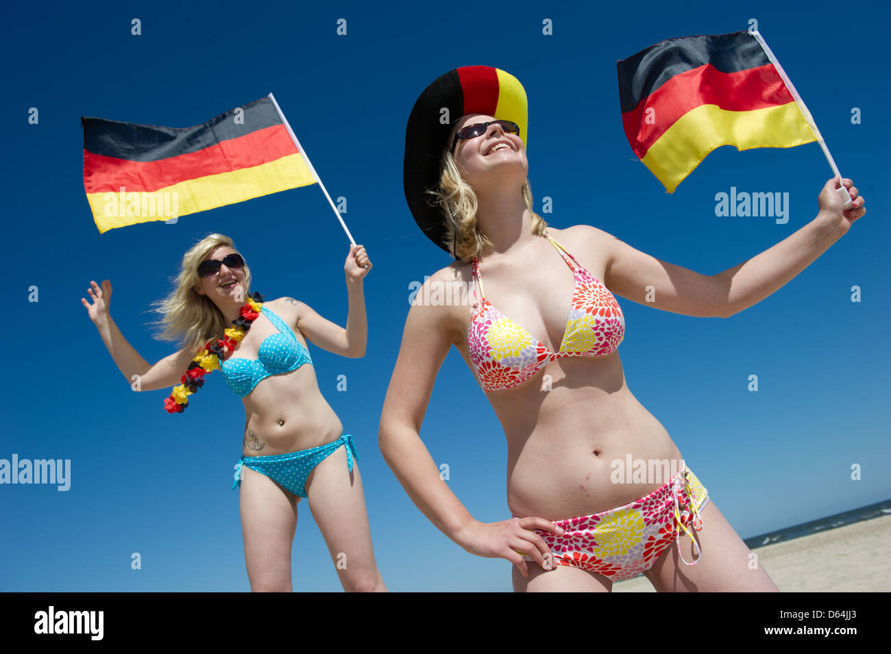 ILLUSTRATION - Natalie and Jule (L-R) hold German flags in preparation for the European Championships at the Baltic Sea beach of Trassenheide, Germany, 25 May 2012. Public broadcaster ZDF plans to cover the Euro 2012 and additional programmes from the Island of Usedom. Photo: Stefan Sauer Stock Photo