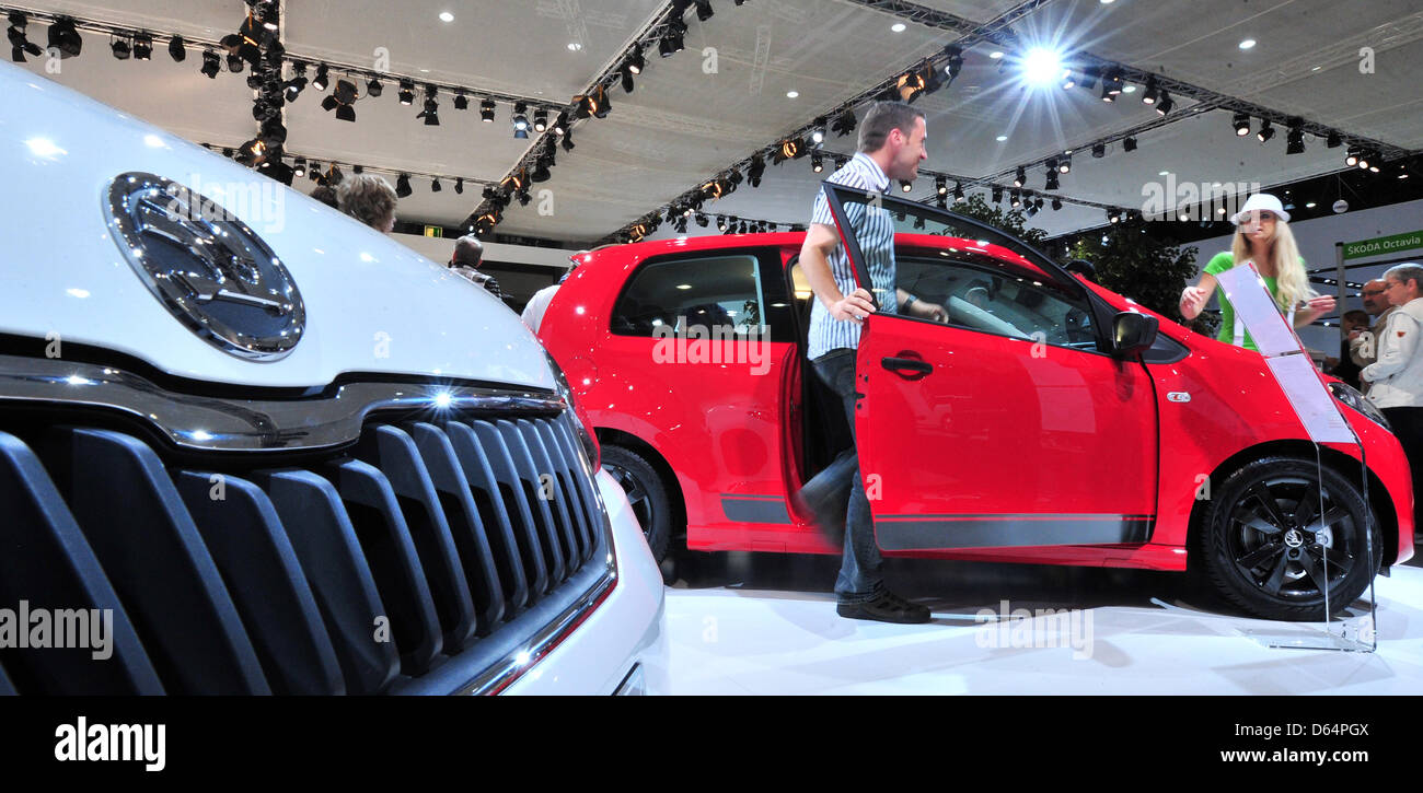 Visitors stroll around exhibited cars and motor vehicles of car manufacturer Skoda, feauturing also Skoda's Citigo, at the automobile fair AMI in Leipzig, Germany, 2 June 2012. German and international car manufacturers present their latest car novelties at the Leipzig trade fair centre from 2 June to 10 June 2012. Around 280,000 visitors are expected to attend the fair which featu Stock Photo
