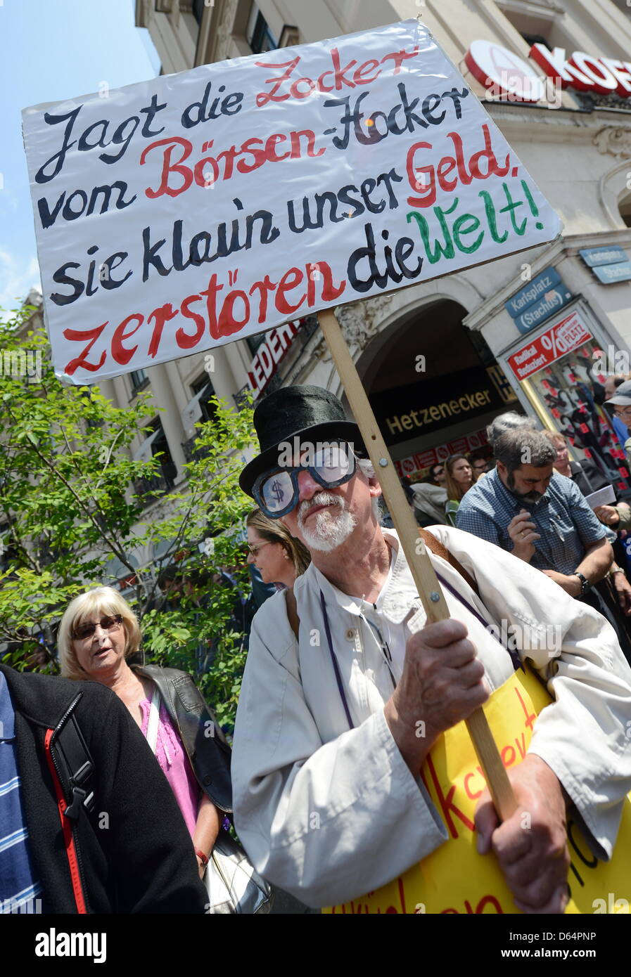 Ein Demonstrant trägt am Samstag (02.06.2012) in München (Oberbayern) bei einer Kundgebung eine Brille mit Euro-Zeichen und ein Plakat. Die Freien Wähler, der Bund der Steuerzahler und weitere Organisationen haben zur Demonstration gegen den Euro-Rettungsschirm aufgerufen. Foto: Tobias Hase dpa/lby Stock Photo
