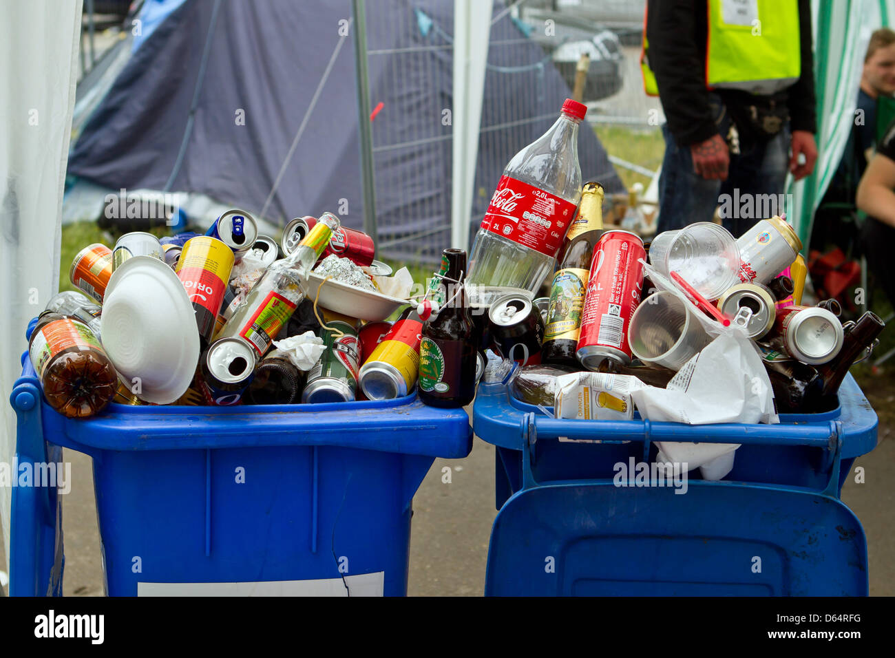 Trash bins are full of empty bottles and rubbish at the entrance to the