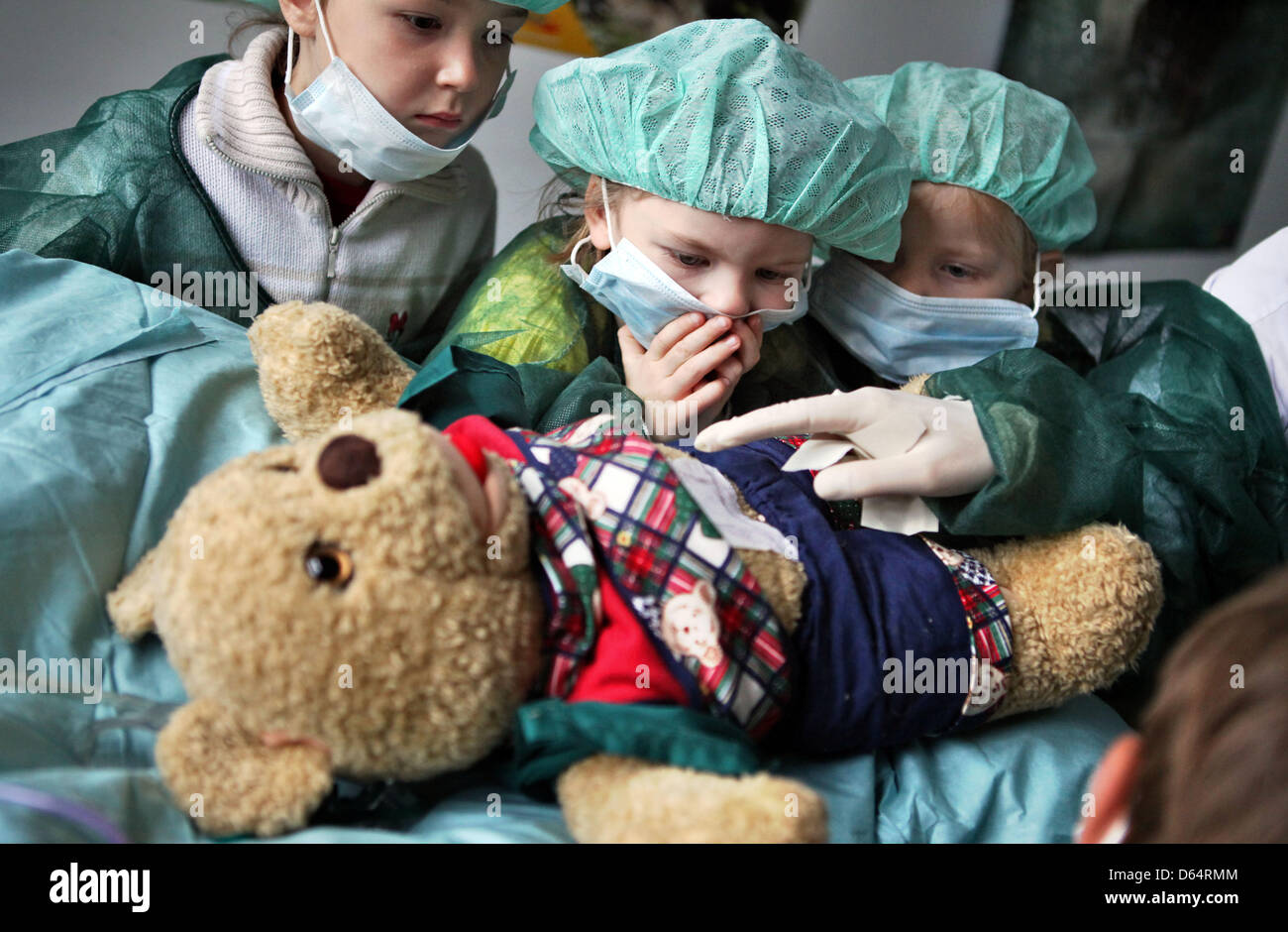 Children watch an operation on the teddy bear 'Mr bear' at the 'Teddy bear clinic' in Halle (Saale), Germany, 04 June 2012. During the surgery the appendix of the bear is removed. The Teddy bear clinic wishes to remove the fear of hospitalisation. Photo: Jan Woitas Stock Photo