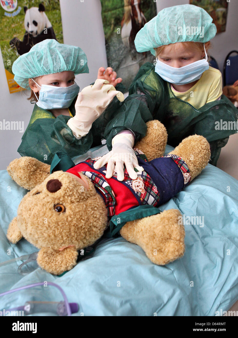 Marie (L) and Anna look at the teddy bear 'Mr bear' at the 'Teddy bear clinic' in Halle (Saale), Germany, 04 June 2012. During the surgery the appendix of the bear is removed. The Teddy bear clinic wishes to remove the fear of hospitalisation. Photo: Jan Woitas Stock Photo