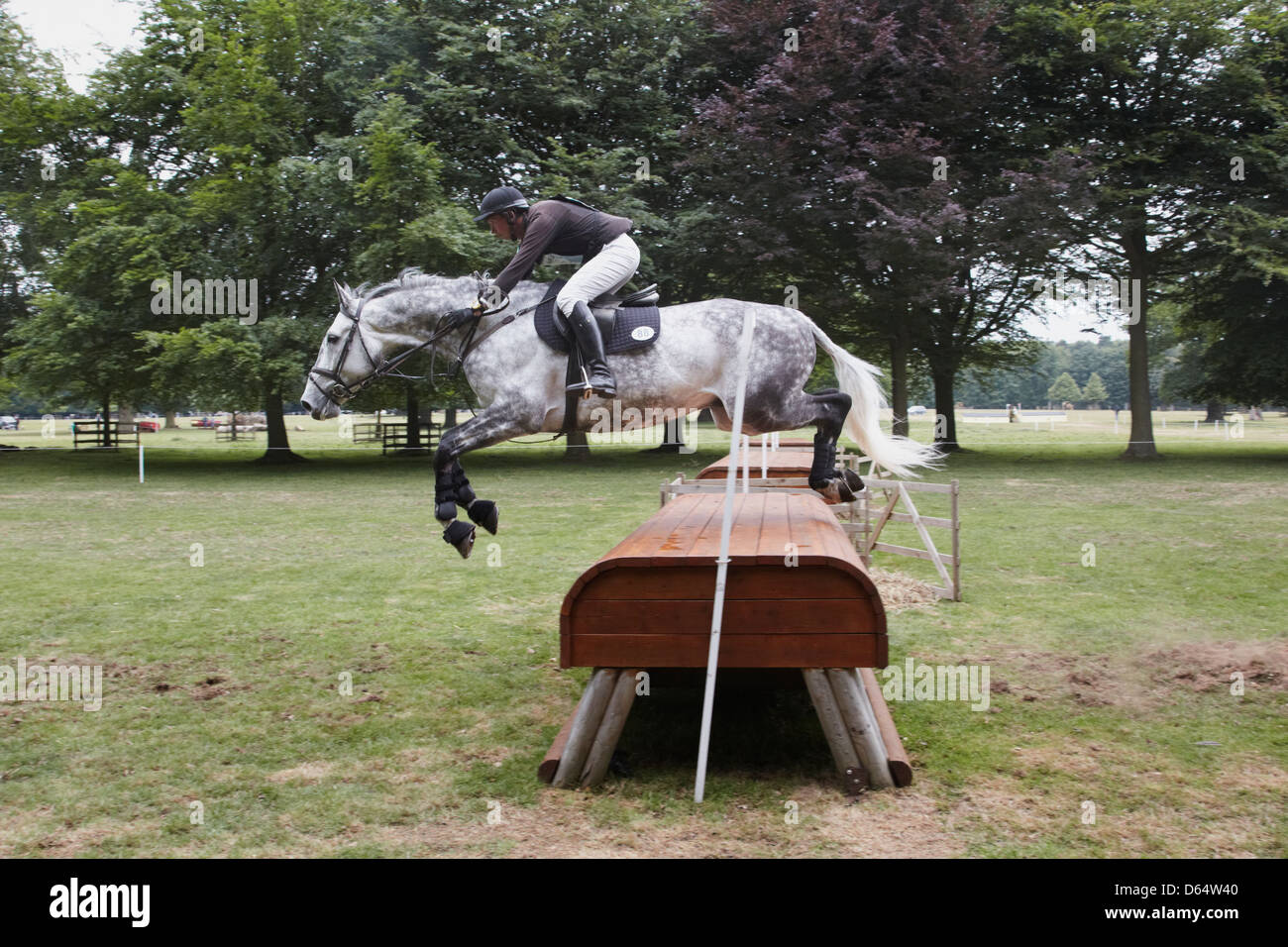 Richard Jones riding Cavalier Ford jumping over hay racks fence on the cross country course Stock Photo