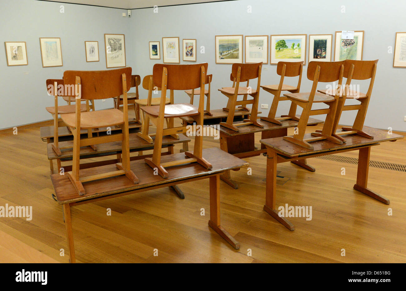 Old school desks are on display with pictures bay artist Jean-Jacques Sempe at the Wilhelm Busch Museum in Hanover, Germany, 08 June 2012. It is part of the exhibition for the 80th birthday of French illustrator Jean-Jacques Sempe. Photo: Peter Steffen Stock Photo