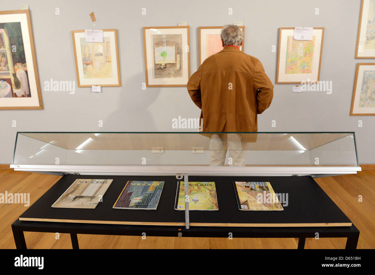 A visitor looks at pictures by artist Jean-Jacques Sempe at the Wilhelm Busch Museum in Hanover, Germany, 08 June 2012. It is part of the exhibition for the 80th birthday of French illustrator Jean-Jacques Sempe. Photo: Peter Steffen Stock Photo