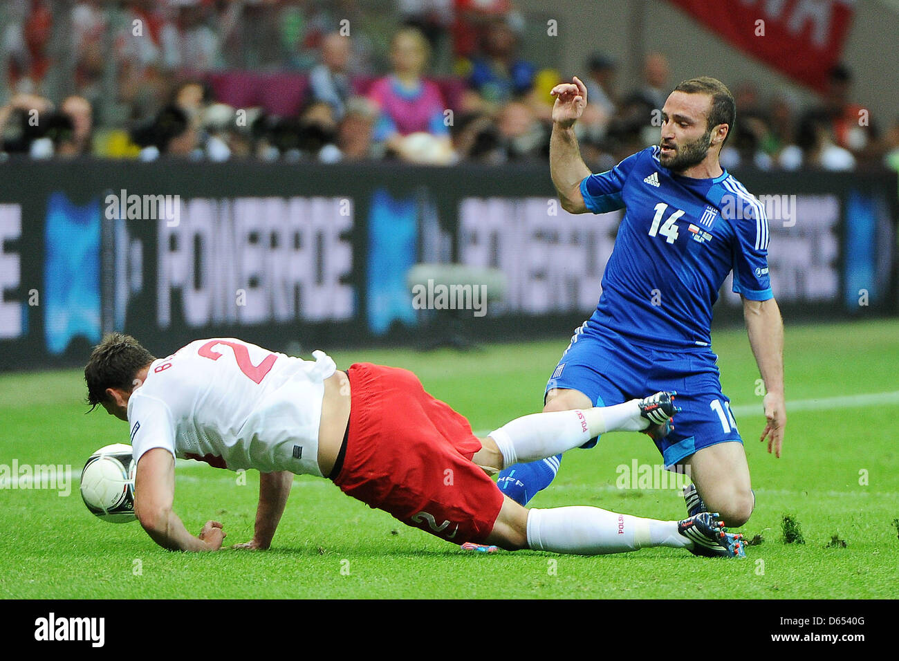 Poland's Sebastian Boenisch (L) vies for the ball with Greece's Dimitris Salpingidis during the UEFA Euro 2012 match between Poland and Greece at the national stadium in Warsaw, Poland, 08 June 2012. Photo: Pressfocus / Revierfoto Stock Photo