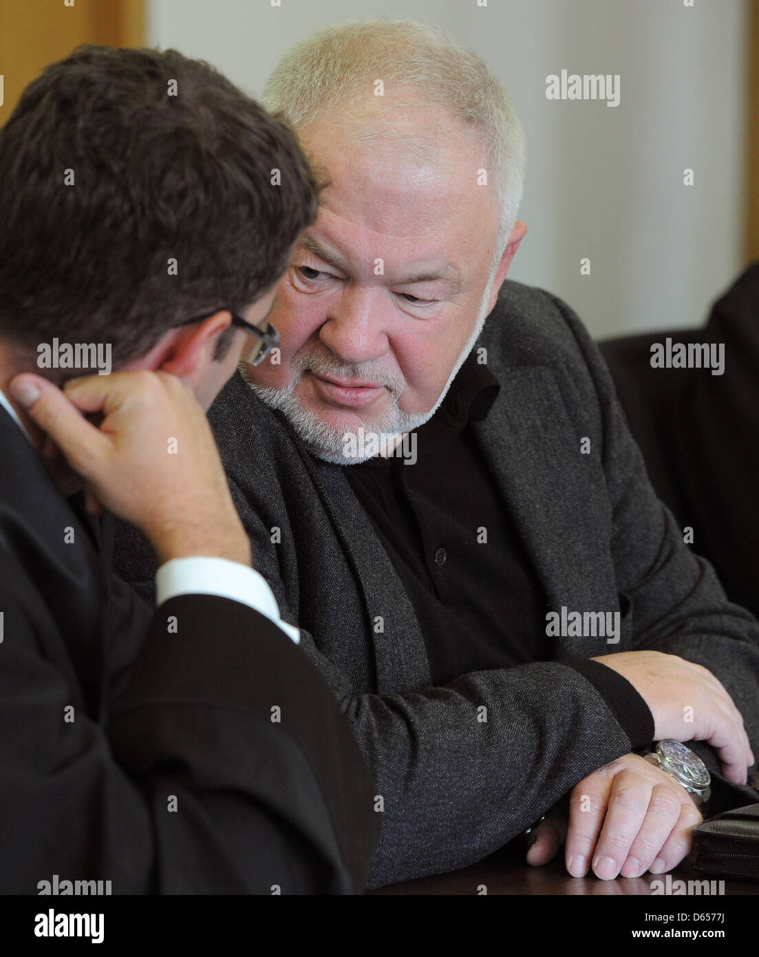 A court bailiff shows hotelier Axel Hilpert (R) talks with his lawyer