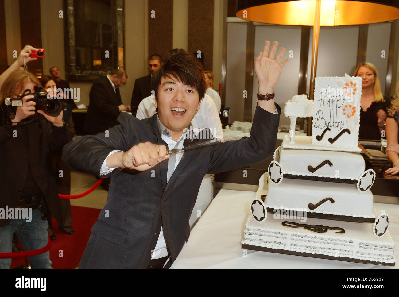 Chinese star pianist Lang Lang poses next to his birthday cake after