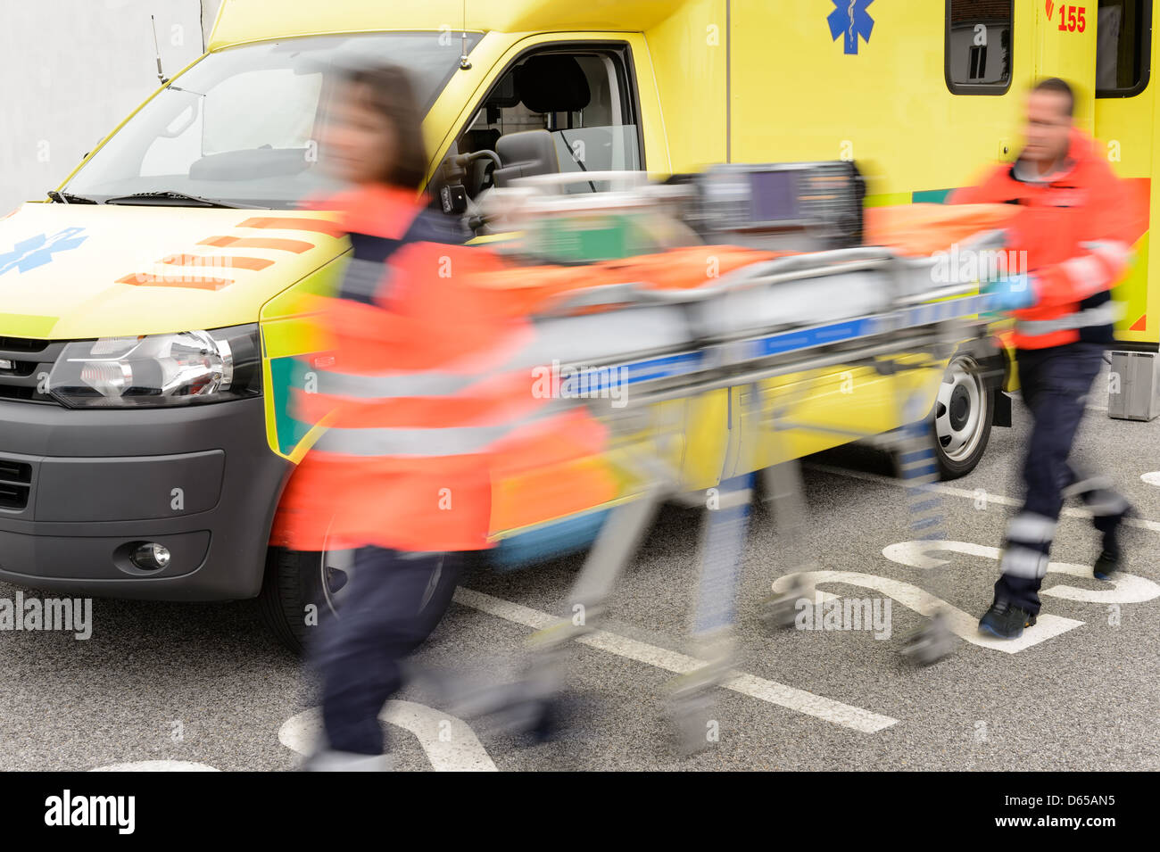 Running blurry paramedics team with stretcher and ambulance car Stock Photo