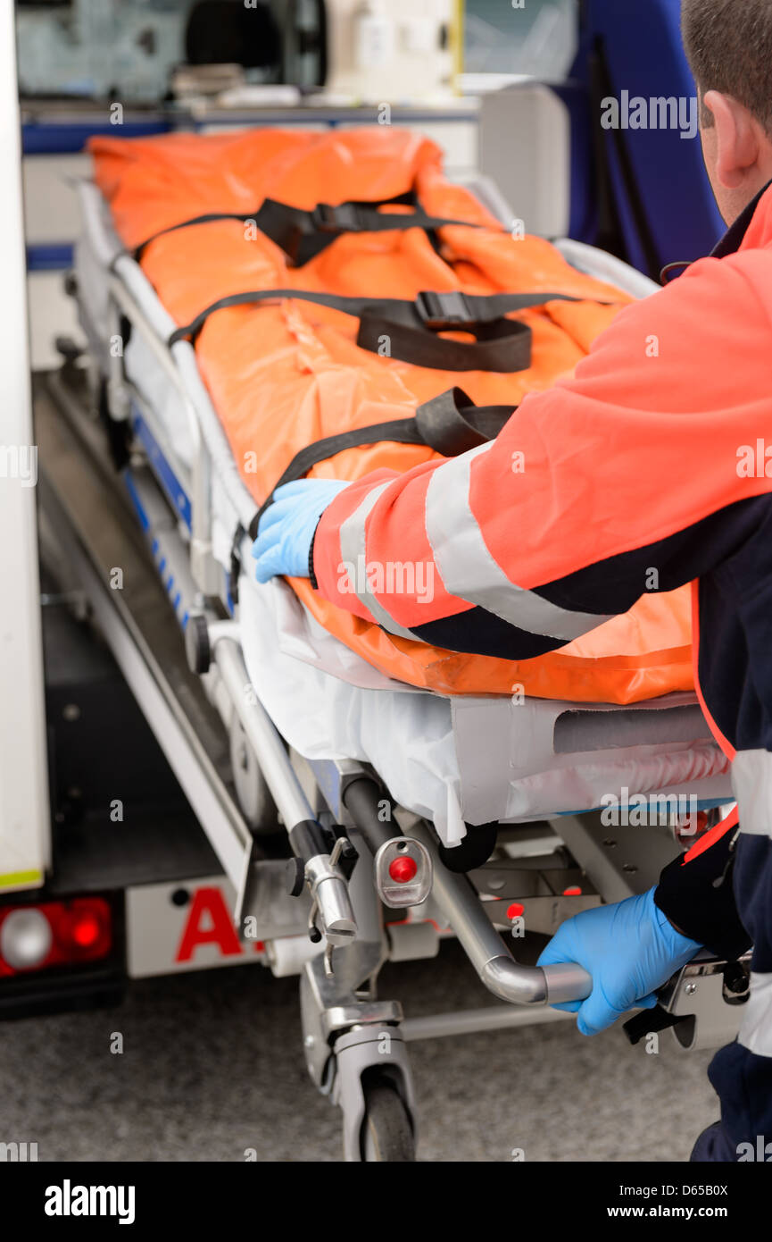 Paramedics rolling out gurney from emergency truck Stock Photo Alamy