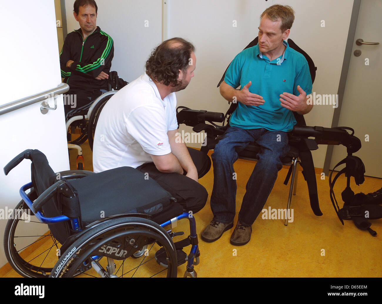 Physiotherapists talk to paraplegic patient after having him try out