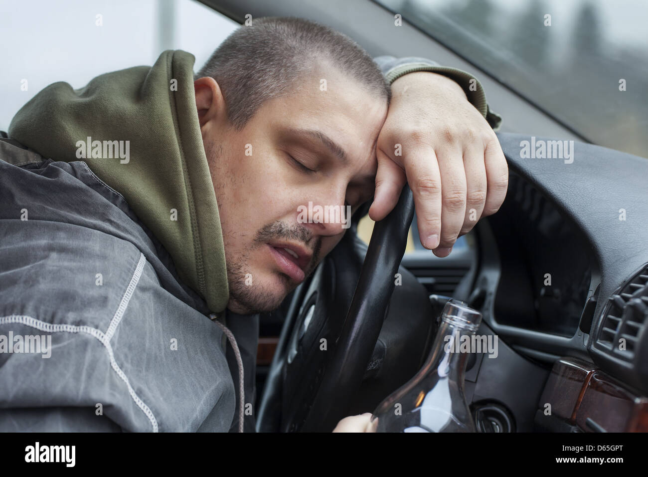 Drunk man lying on the steering wheel Stock Photo