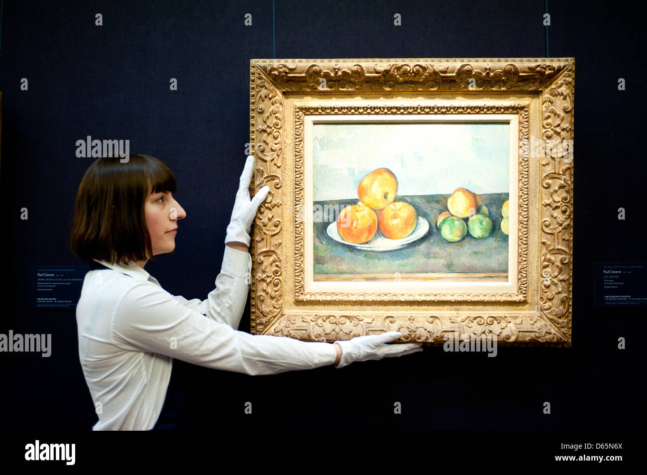 London, UK. 12th April 2013. A Sotheby's employee poses in front of Paul Cezanne 'Les Pommes 1889-1890'  (Est. $25-35 million). The work will go on sale at Sotheby’s New York in May 2013. The Blockbuster sales at include works by Richter, Modigliani, Picasso, Rodin, Bacon, Cezanne. Credit: Piero Cruciatti / Alamy Live News Stock Photo