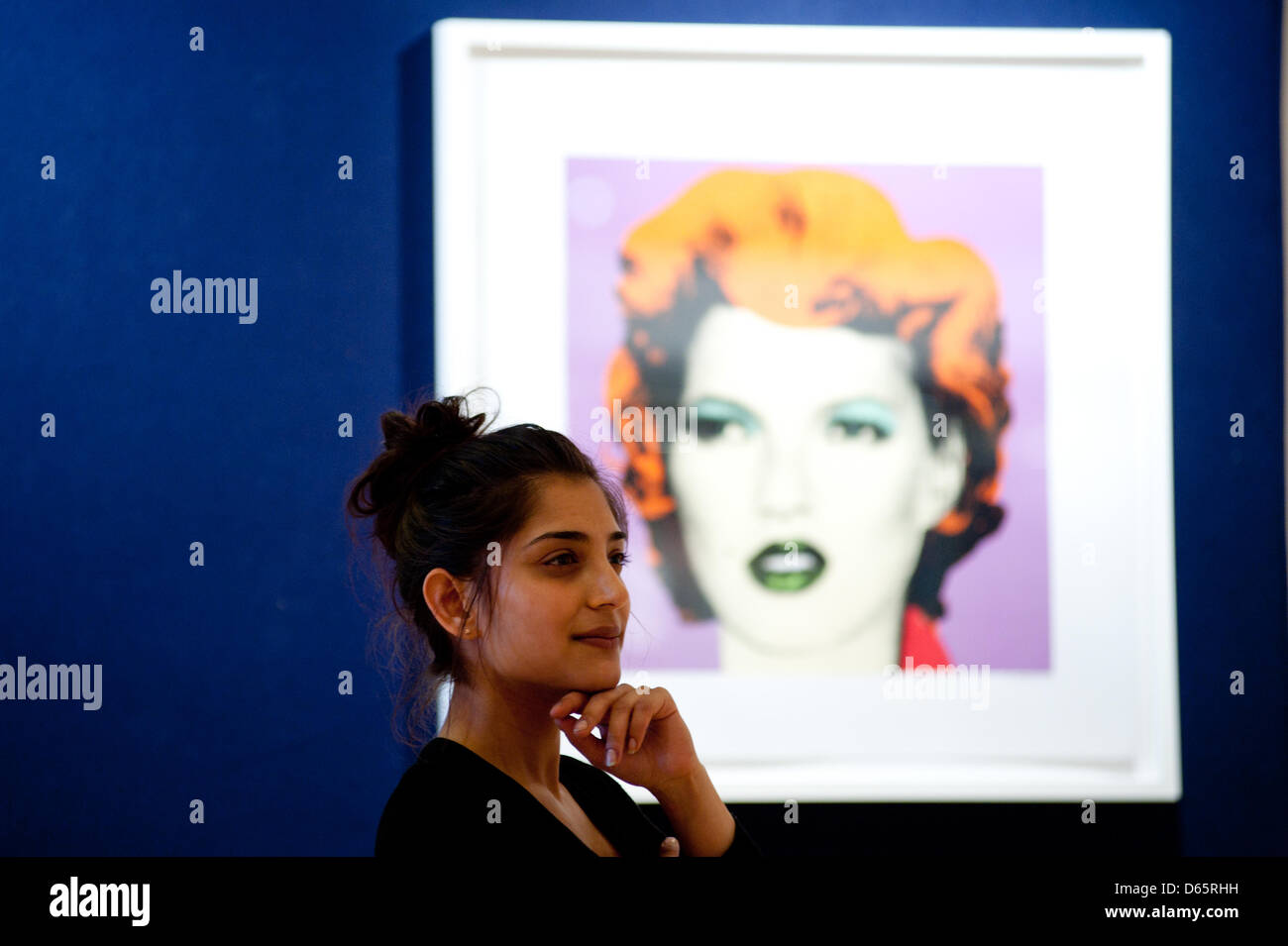 London, UK. 12th April 2013. a sales assistant poses for a picture next to a work entitled “Kate Moss (Purple and Orange' by Banksy during the 'Urban Art' auction preview at Bonhams. Credit: Piero Cruciatti / Alamy Live News Stock Photo