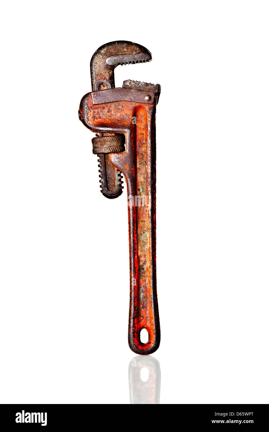 A beat up well used red monkey wrench standing upright on handle on reflective white Plexiglass. Stock Photo