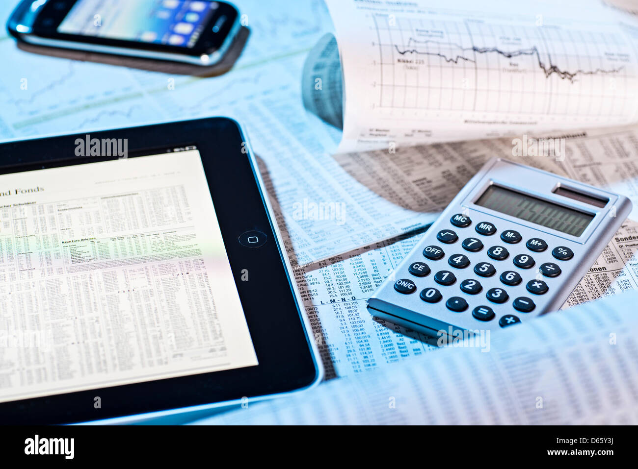 Stock prices in the newspaper and on the screen of a tablet computer