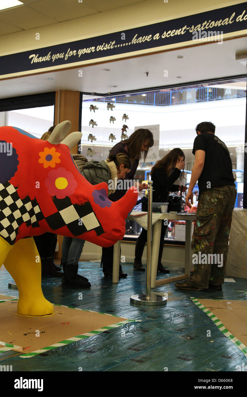 Southampton, UK. 12th April 2013 - Will Rosie (right) from All About Art Ltd. greeting members of the public and getting them to place a tile on his rhino sculpture for Go! Rhinos at Marlands Shopping Centre. The finished Rhinos will be displayed on sculpture trails throughout the city this summer from July to September before moving to Marwell Zoo in October where they will be sold at auction. Proceeds will benefit Marwell Wildlife, Wessex Heartbeat's High 5 Appeal and The Rose Road Association. Credit: Rob Arnold/Alamy Live News Stock Photo