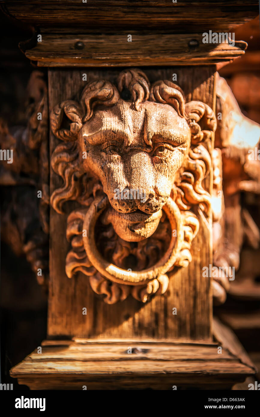 Face of a carved wooden lion, which is illuminated by the sun. Stock Photo