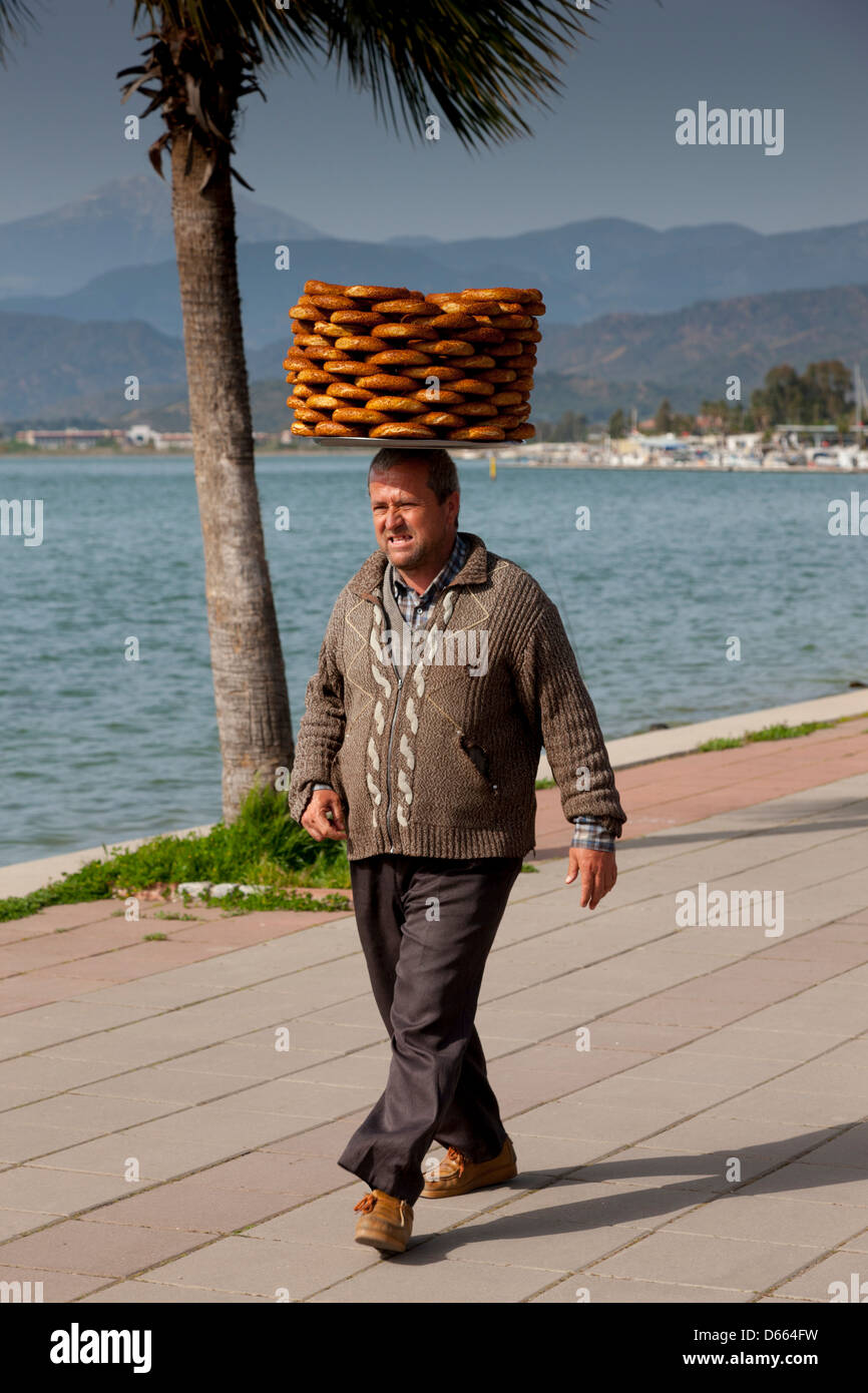 Turkish man carrying a tray of Simit (Turkish Bread Rings) on his head in Fethiye, Turkey Stock Photo