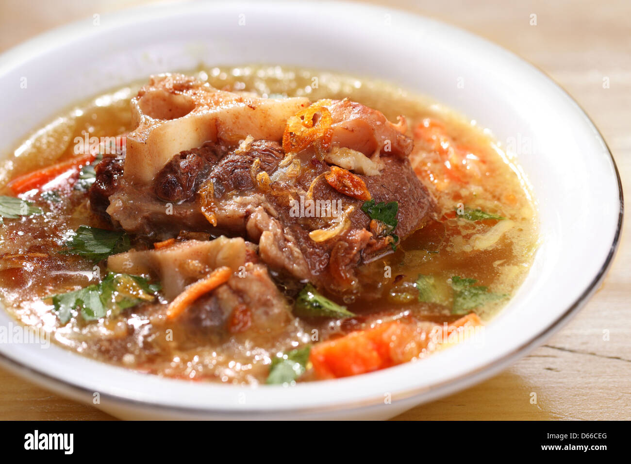 Indonesian delicate famous oxtail soup stew served in a bowl Stock Photo