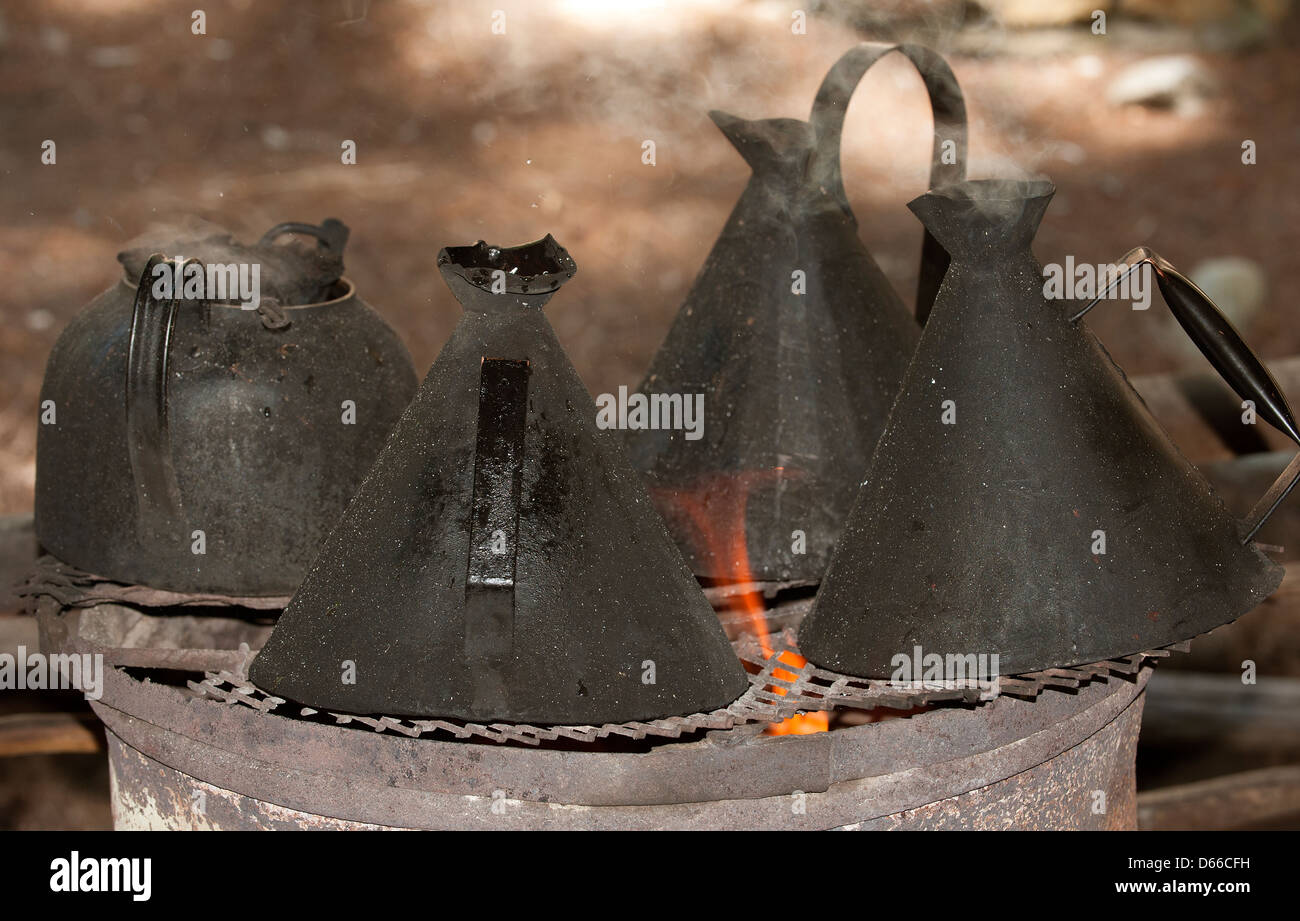 Black kettles for boiling water on an open fire Stock Photo