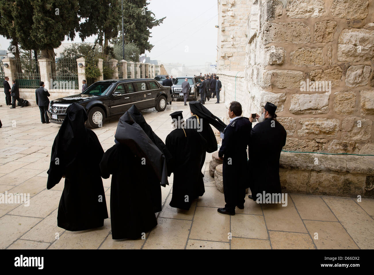 Clergy watch as the US President's motorcade prepares to depart the Church of the Nativity March 22, 2013 in Bethlehem, the West Bank. Stock Photo