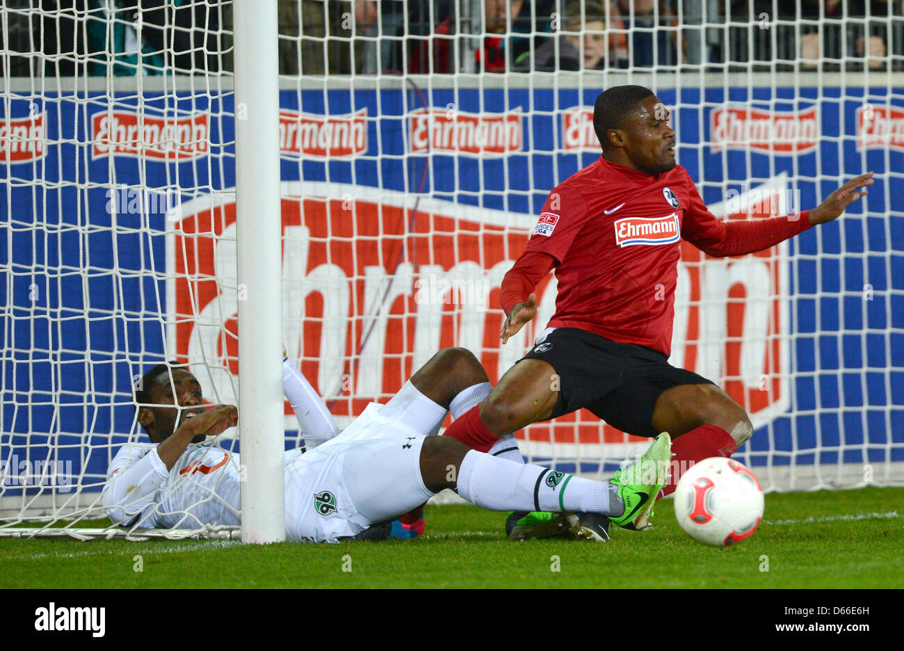 Freiburg's Cedrick Makiadi (R) and Hanover's Johan Djourou (L) fall down during the German Bundesliga soccer match between SC Freiburg and Hannover 96 at Mage Solar Stadium in Freiburg, Germany, 12 April 2013. Photo: Patrick Seeger Stock Photo