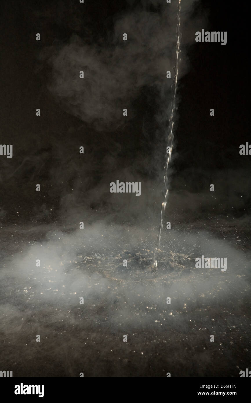 A stream of liquid nitrogen at 200degC being poured into a watchglass causing clouds of misty