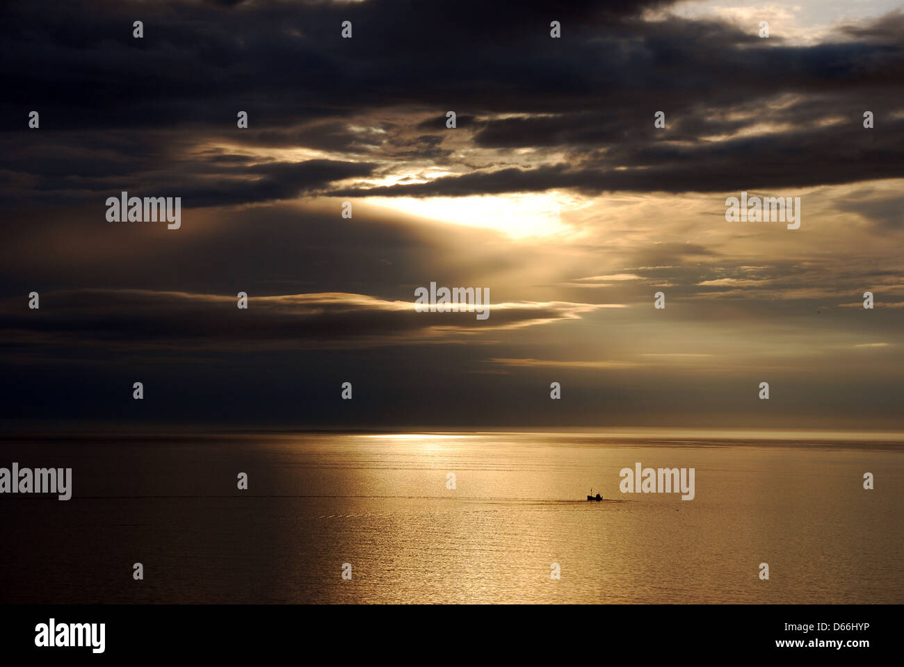 Lonely boat at sea by sunset Stock Photo - Alamy