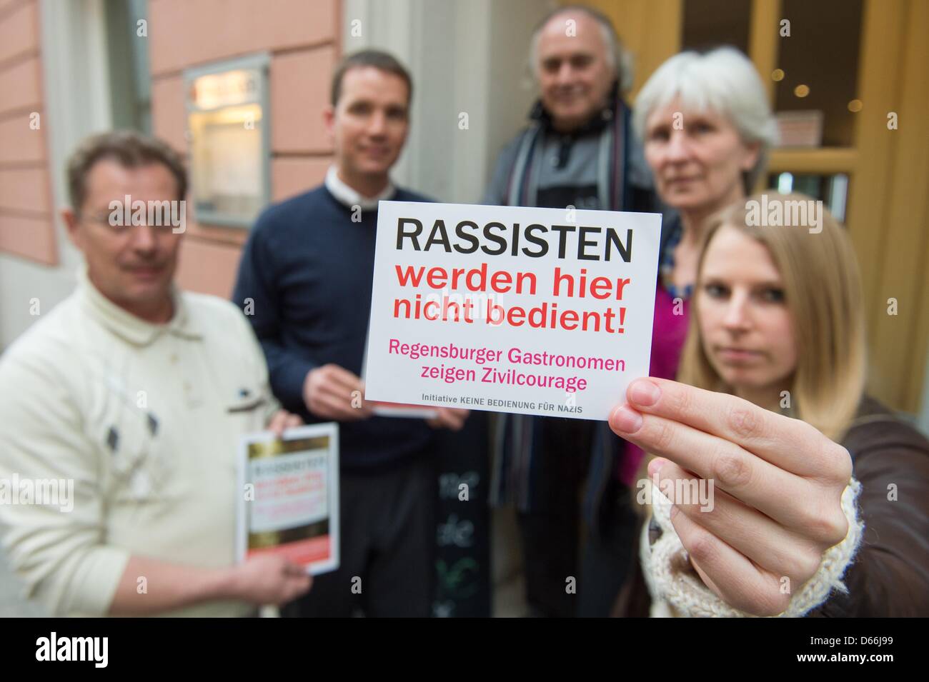 Ina Schneider of the initiative 'No service for Nazis' holds up a sign with the same phrase next to Richard Spiess (L-R), Ludwiag Simek, Sion Israel and Helga Hanusa at the Cafe Picasso in Regensburg, Germany, 08 April 2013. On 13 April 2013, the initiative will receive the Luther Prize 'The Bold Word'. Photo: Armin Weigel Stock Photo