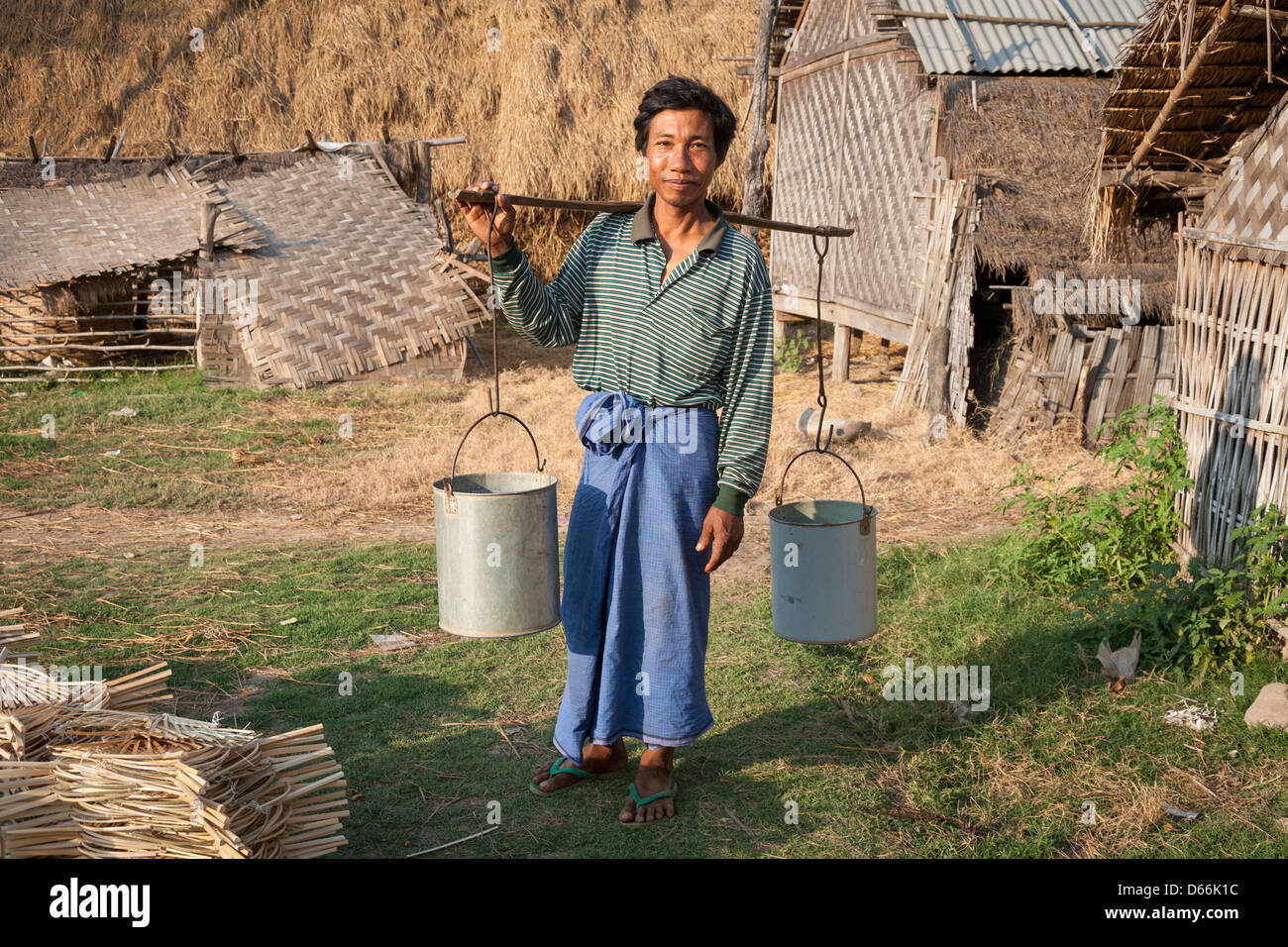 Man carrying pannier for water, Yay Kyi village, Mandalay, Myanmar, (Burma) Stock Photo