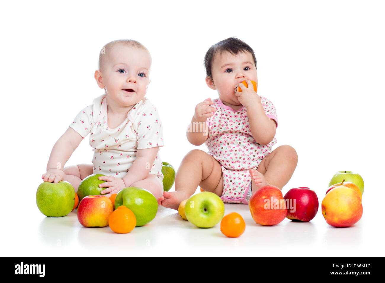 kids babies eating healthy food fruits isolated on white Stock Photo
