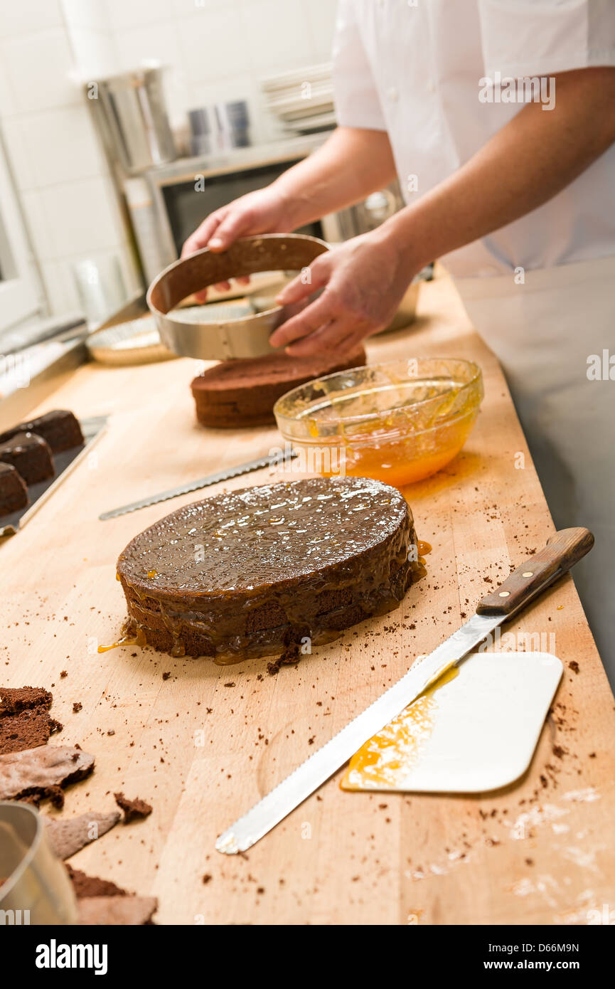 Cook taking out cake from springform pan in kitchen Stock Photo Alamy