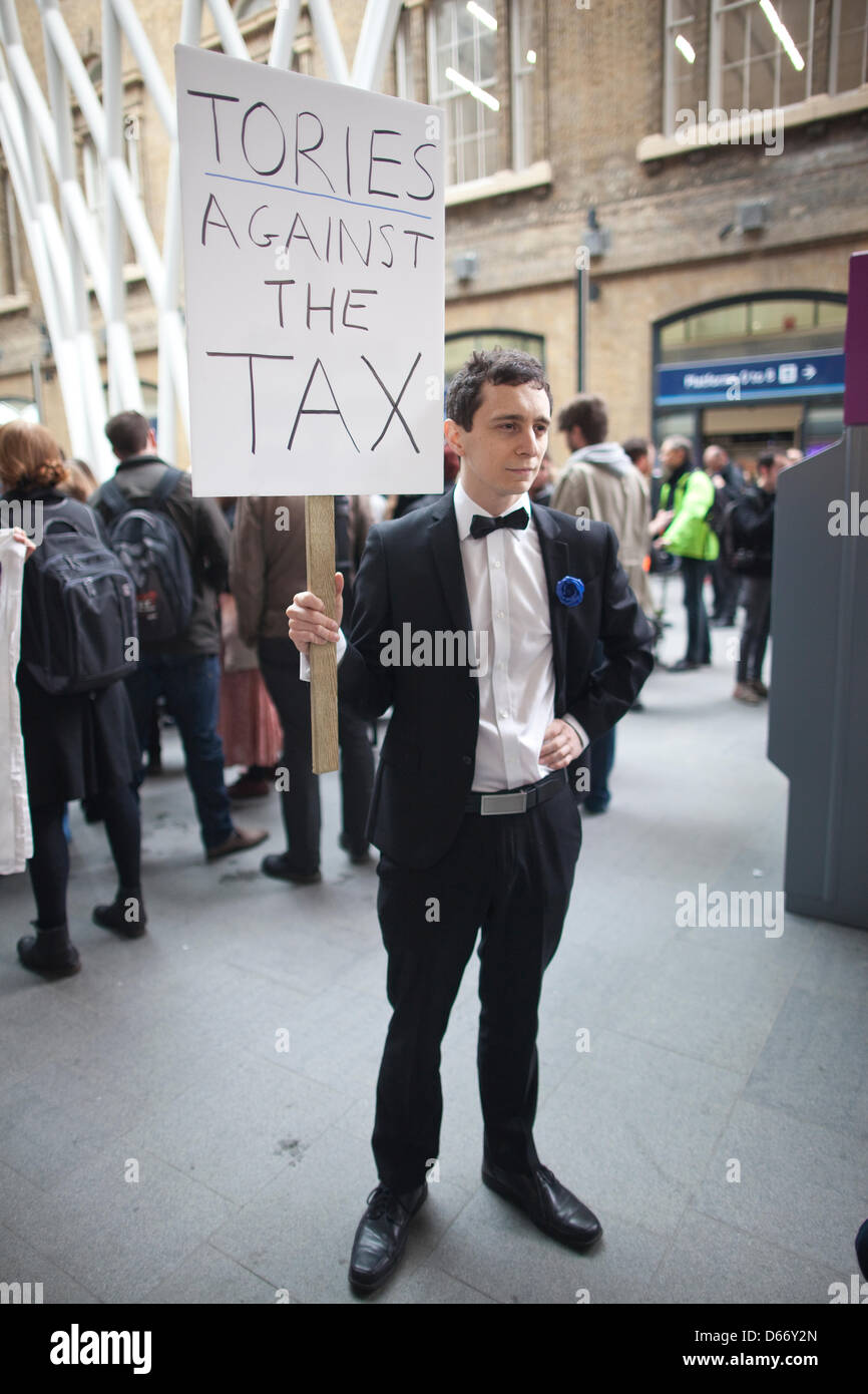 London, UK. 13 April 2013. Bedroom Tax protest, Kings Cross Station, London, England, UK. A man dressed in black tie at Kings Cross station, one of hundreds of anti-cuts activists who delivered 'eviction notices' to the home of Lord Freud in civil disobedience actions to protest at the Government's controversial welfare changes. The effect of the so-called 'bedroom tax' is being highlighted, with protesters taking beds with them during the demonstrations, and removal trucks unloading furniture into the streets. Jeff Gilbert/Aamy Live News Stock Photo