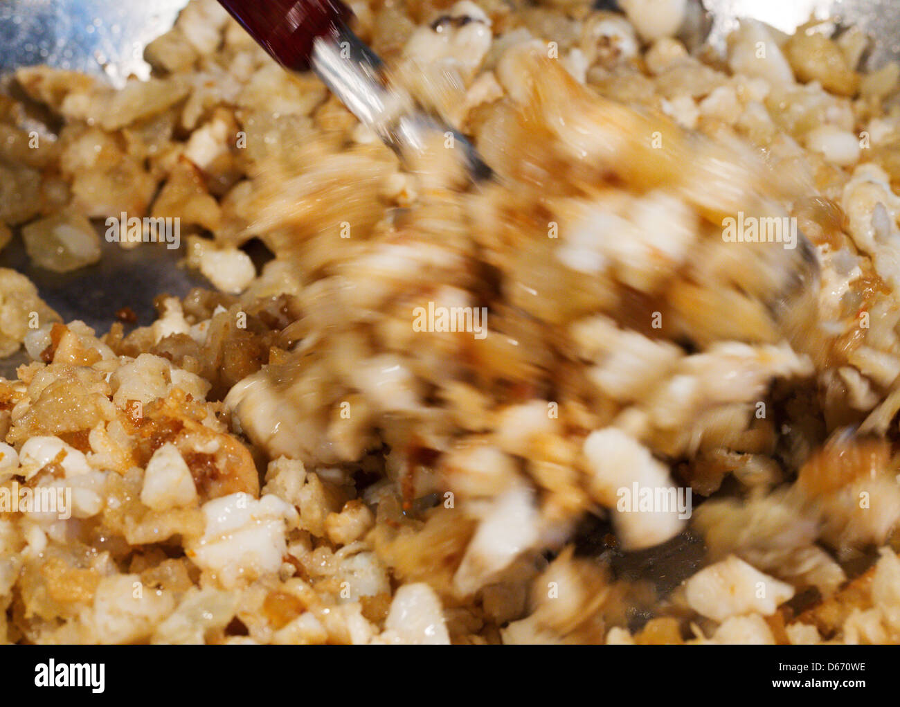 Fried cracklings actively mixed in a pan Stock Photo