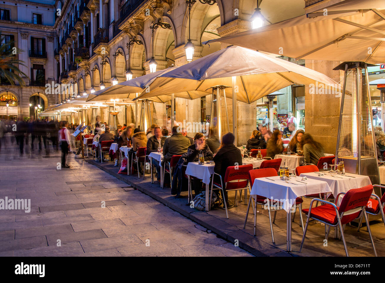 Night view of an outdoor restaurant cafe with people seated at tables, Plaça Reial  or Plaza Real, Barcelona, Catalonia, Spain Stock Photo