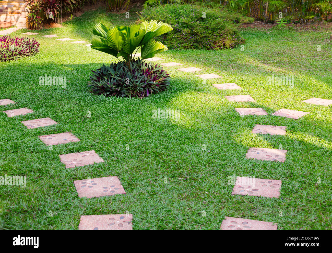 Garden path with grass growing up between the stones Stock Photo