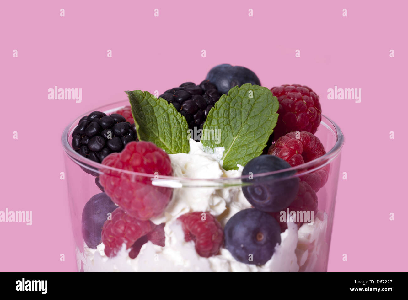 Yogurt mousse dessert with colorful berries and mint leaves Stock Photo