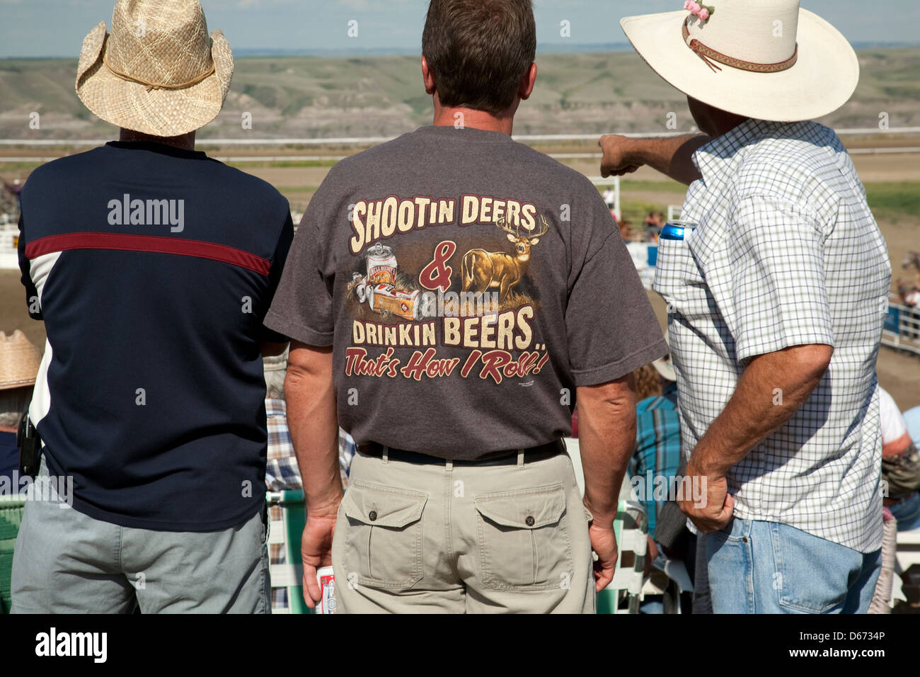 Three cowboys watch the rodeo in Drumheller, Alberta Stock Photo