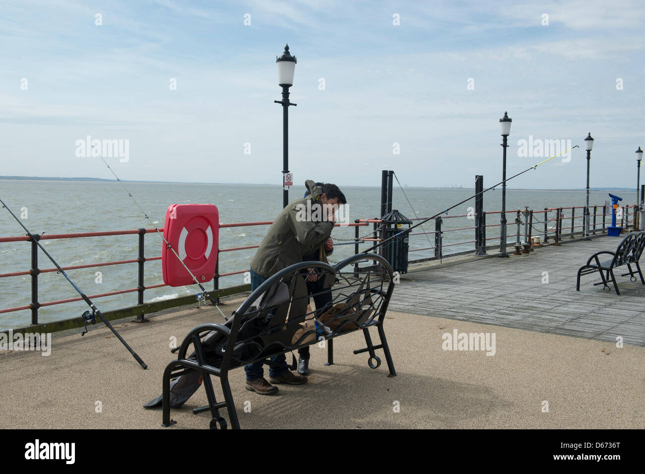 Anglers fishing at the end of Southend Pier, Essex, UK. It is the world's longest pleasure pier at 1.3 miles in length. Stock Photo